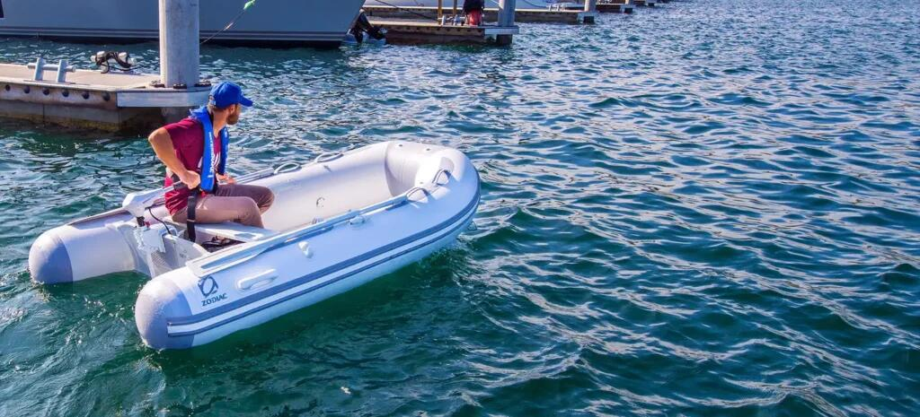 Hombre navegando en una embarcación neumática Zodiac con un motor eléctrico Watersnake en el espejo de popa.
