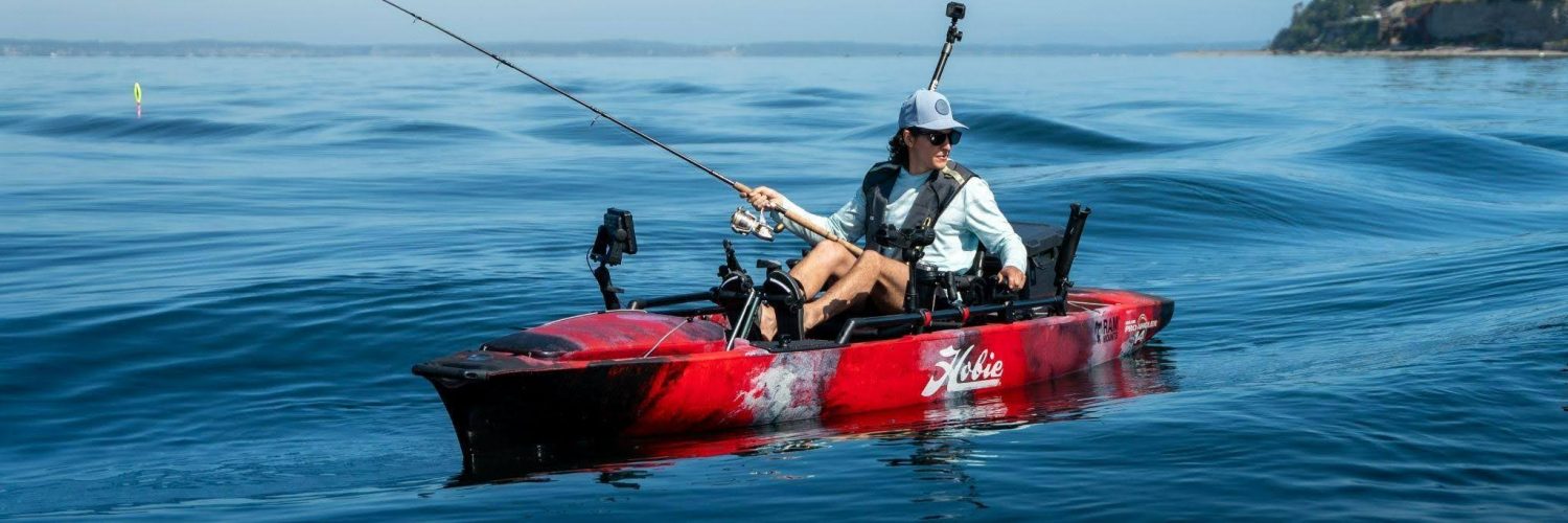 Pescador navegando en kayak Hobie equipado con caña de pesca y accesorios en mar abierto