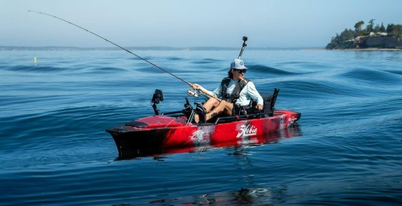 Pescador navegando en kayak Hobie equipado con caña de pesca y accesorios en mar abierto