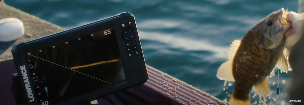 Pescador mostrando una captura de Black Bass junto a la pantalla de la sonda Lowrance Eagle Eye 9 montada en la embarcación
