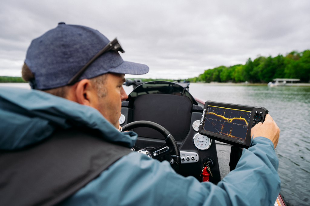 Pescador al volante de su embarcación consultando la pantalla de la sonda GPS plotter Lowrance Eagle Eye 9 montada en la consola.