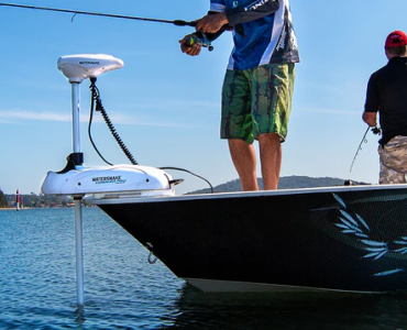 Dos pescadores a bordo de una embarcación utilizando un motor eléctrico Watersnake con GPS en la proa para mantener la posición.