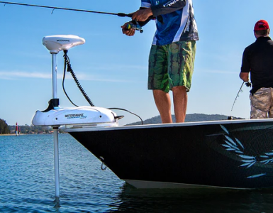 Dos pescadores a bordo de una embarcación utilizando un motor eléctrico Watersnake con GPS en la proa para mantener la posición.
