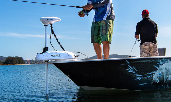 Dos pescadores a bordo de una embarcación utilizando un motor eléctrico Watersnake con GPS en la proa para mantener la posición.