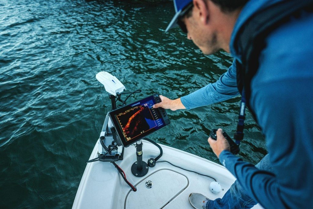 Pescador utilizando una sonda Lowrance en la embarcación durante una jornada de pesca